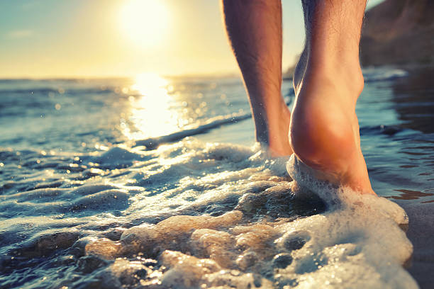 enjoying a barefooted walk at the ocean - voeten in het zand stockfoto's en -beelden