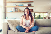 Portrait of a smiling young woman relaxing on the sofa at home