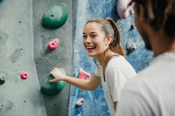 Enjoying A Rock Climbing Session Young woman is laughing while enjoying a rock climbing session with her friends. chalk rock stock pictures, royalty-free photos & images