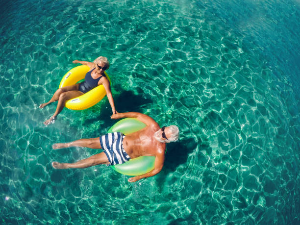 Enjoying our best years Photo of a senior couple floating in the ocean in an inflatable rings and enjoying the best years of their lives baby boomers stock pictures, royalty-free photos & images