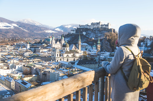 Young woman in winter coat is enjoying the view over Salzburg, historic center