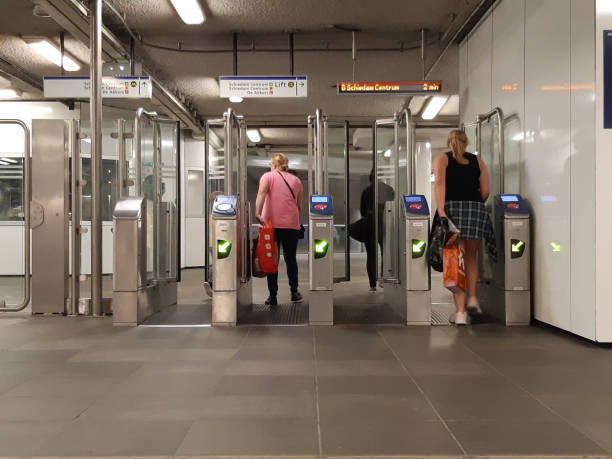 toegangspoorten met draaihekken van de metro in rotterdam met mensen die passeren - rotterdam station stockfoto's en -beelden