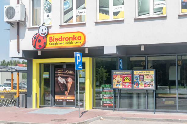 entrance to biedronka - one of the largest chain supermarkets in poland. - biedronka imagens e fotografias de stock