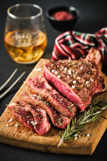 Entrecote. Steak on the bone. Rib eye. Tomahawk steak on the on a cutting board with rosemary. Roasting - Rare stock photo