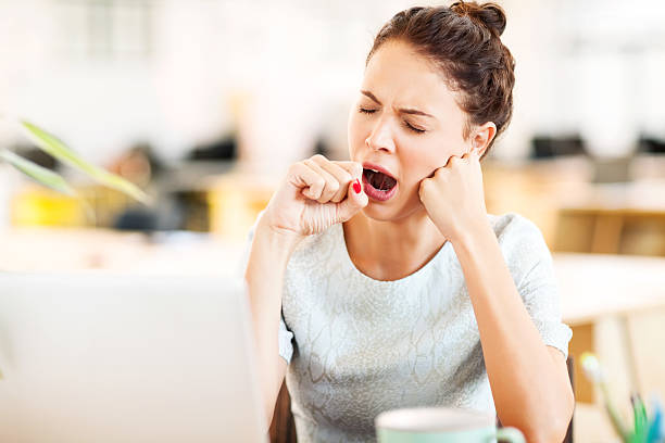 Entrepreneur Yawning In Office Tired female entrepreneur yawning in office. Horizontal shot. tired stock pictures, royalty-free photos & images
