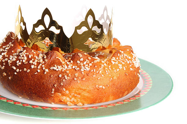 Sugar Epiphany cake in his dish with the paper crown, isolated on white background.