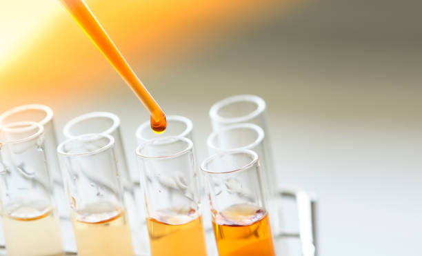 attrezzature e vetrerie per l'estrazione di prodotti di prova e la soluzione di colore arancione, nel laboratorio di chimica. - laboratorio scientifico foto e immagini stock