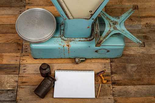 Equipment of the old store. Weight, notebook and goods on the shop table. Dark background.