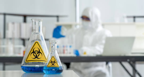 Erlenmeyer Flask contains blue liquid chemicals on a white laboratory table. stock photo