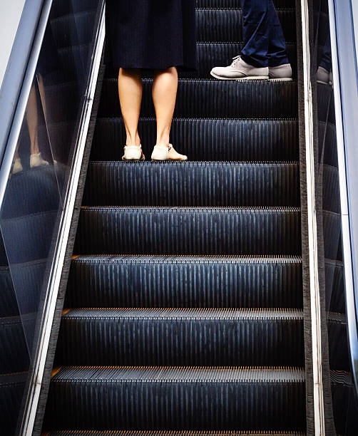 An Escalator with two passengers going up.