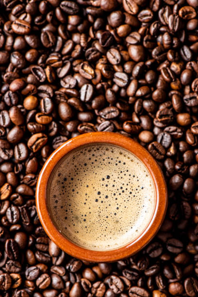 Espresso coffee mug over coffee beans stock photo