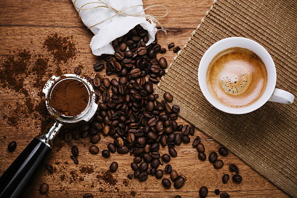 Espresso on a wooden table Espresso coffee overhead with spout and coffee beans on a wooden table espresso stock pictures, royalty-free photos & images