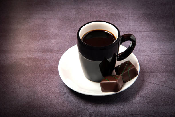espresso with chocolate bonbons A cup of espresso with chocolate bonbons. semi sweet chocolate stock pictures, royalty-free photos & images