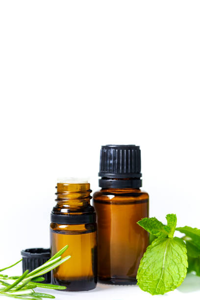 Essential oils in dark glass bottle with aroma herbs. stock photo