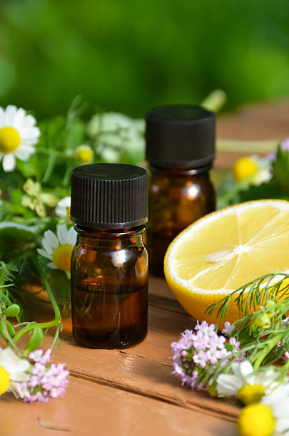 essential oils with lemon and herbs stock photo