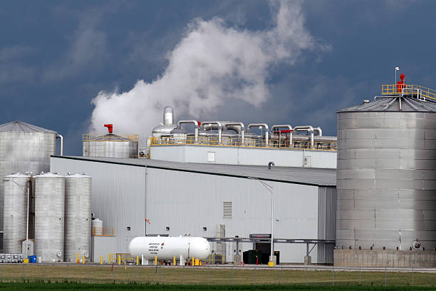 Ethanol Plant Production Closeup View of Iowa biorefinery in summer against stormy summer sky. ammonia stock pictures, royalty-free photos & images