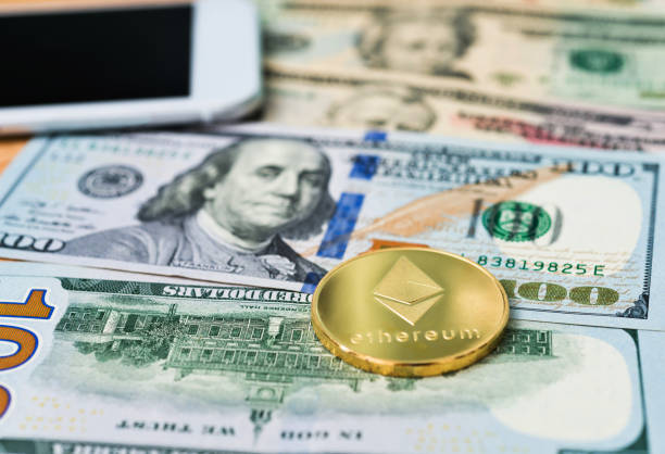 Ethereum coin and smart phone on Dollar bills Fujian, China - May 30, 2018: Ethereum coin and smart phone on Dollar bills. Ethereum is virtual currency.  With Ethereum  stock pictures, royalty-free photos & images