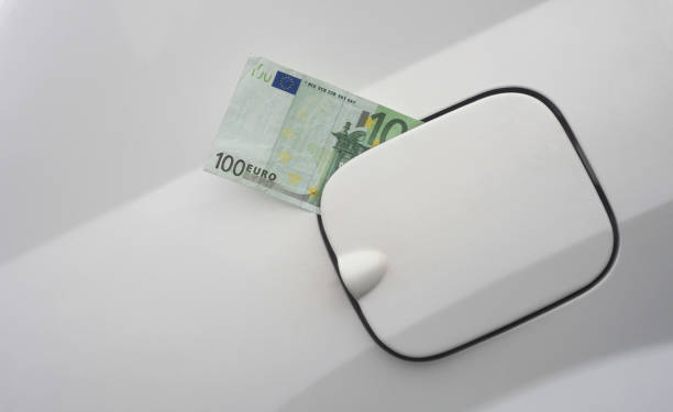 euro banknote in the fuel tank of car. stock photo