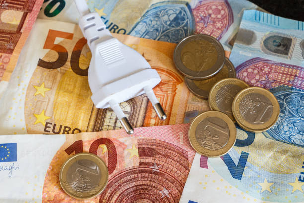 Euro coins, notes and electric plug stock photo