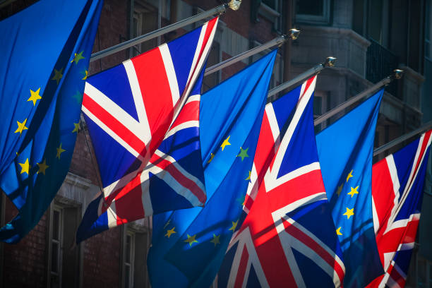European Union and United Kingdom flags together on sunny day Flags of the European Union and United Kingdom alongside each other brexit stock pictures, royalty-free photos & images