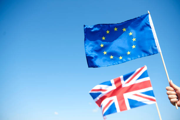European Union Flag and blurred British flag in the background European Union Flag and blurred British flag in the background brexit stock pictures, royalty-free photos & images