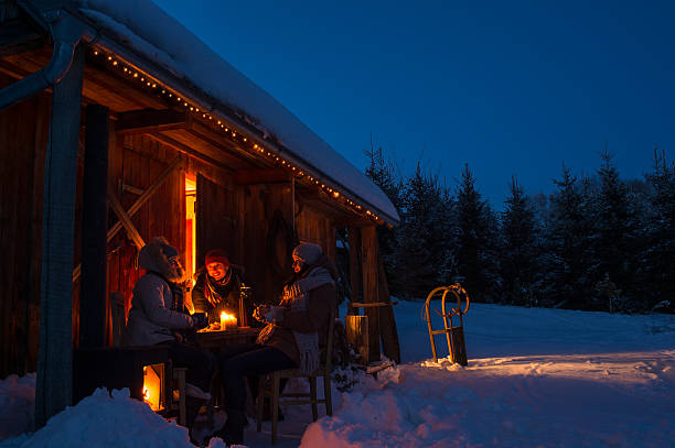 Evening snow winter cottage friends enjoy hot drinks stock photo