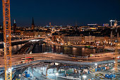 Evening street in Stockholm, repair of bridge and road. Night cityscape from above in warm colors.
