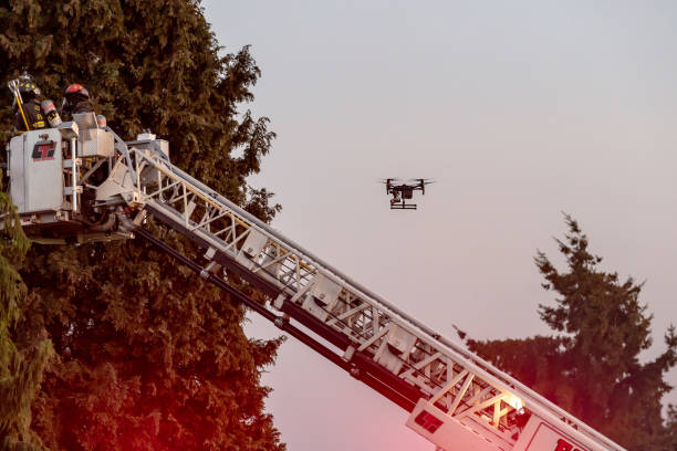 Everett WAshington, USA / 05/09/2019 - House Fire Fireman Try To Contain Fire on Roof on old Ballon Frame Home as a drone records the action stock photo