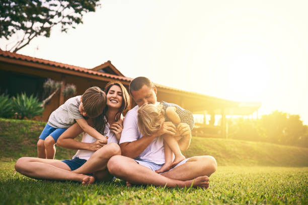 Every moment spent together is absolute bliss Shot of a happy family bonding together outdoors yard grounds photos stock pictures, royalty-free photos & images