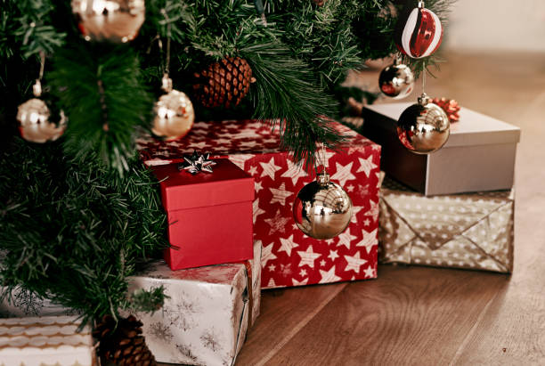 Cropped shot of a bunch of presents placed under a Christmas tree ready to be opened in the morning