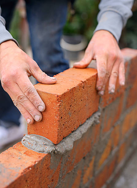Everything is built one brick at a time Shot of a master bricklayer at work bricklayer stock pictures, royalty-free photos & images