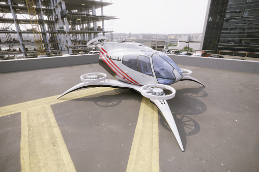 eVTOL-Electric Vertical Take Off standing on rooftop landing pad between the buildings. (3d render)