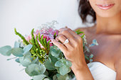A beautiful young bride looking at her bridal bouquet