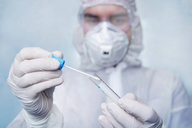 Examination of mucosal smears. The scientist is holding a test tube. Study of viruses in sputum of the lungs. Test for flu or coronavirus infection. Development of biological weapons. stock photo