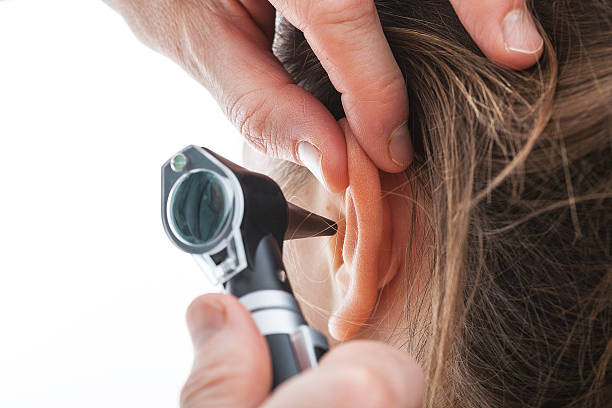 Examining ear with otoscope stock photo