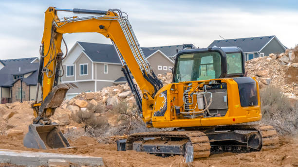 Excavator against homes and sky in Utah Valley stock photo