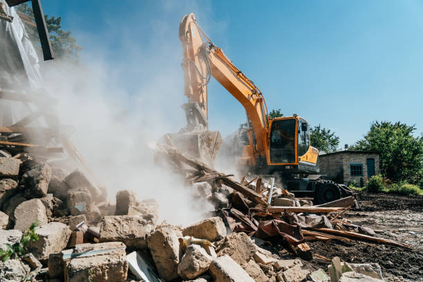 Excavator destroy old house. Demolition of building stock photo