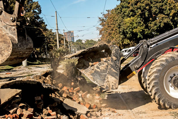 Excavator, grader and workers remove debris after dismantling a tram stop. stock photo