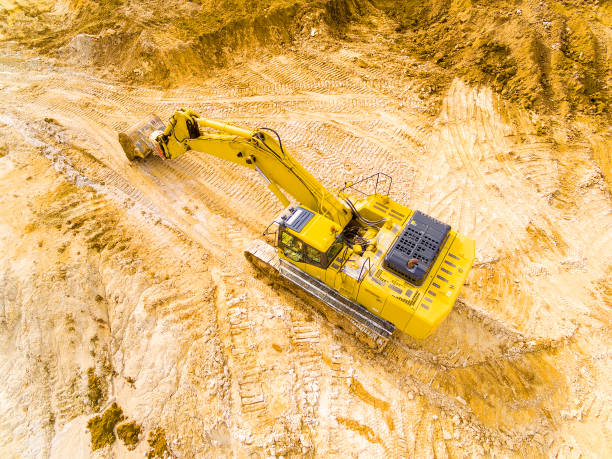 Excavator in open cast mine. Aerial view of a excavator in open cast mine or on construction site. Heavy industry from above. Industrial photography from drone. erosion control stock pictures, royalty-free photos & images