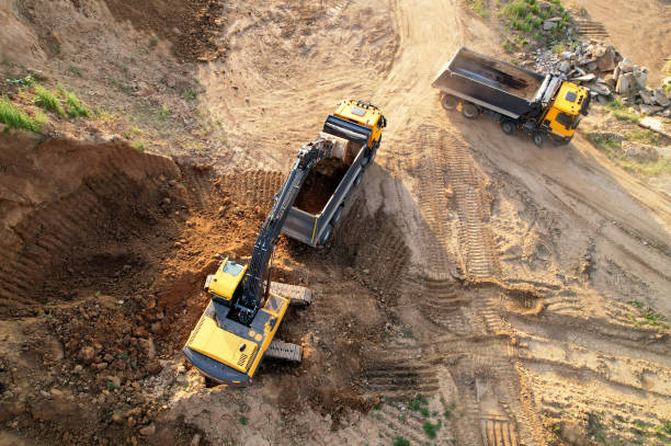Excavator load the sand into dump truck. Aerial view of an backhoe on earthworks. stock photo