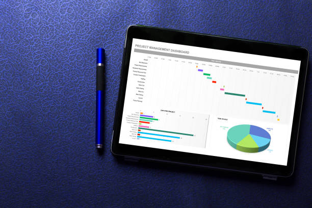Excel project dashboard concept on tablet screen with blue pen on blue pattern textured background stock photo