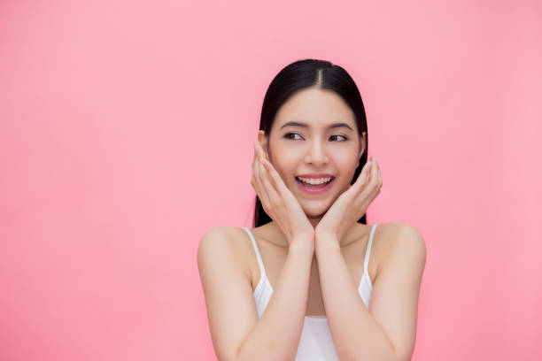 Excited and surprised smiling Asian 20s woman isolated over pink background. Excited and surprised smiling Asian 20s woman isolated over pink background cute thai girl stock pictures, royalty-free photos & images