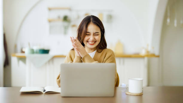 Excited asian female feeling euphoric celebrating online win success achievement result, young woman happy about good email news, motivated by great offer or new opportunity, passed exam, got a job stock photo