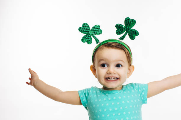 Excited child with arms out and St.Patrick's Day clover head decoration stock photo