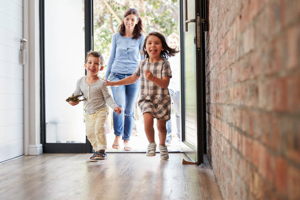 Excited Children Arriving Home With Parents  returning home stock pictures, royalty-free photos & images