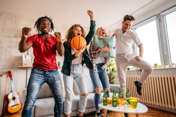 Excited fans cheering for sport team watching basketball game Young men and women with beer and popcorn cheering for winner team while watching basketball game. match sport photos stock pictures, royalty-free photos & images