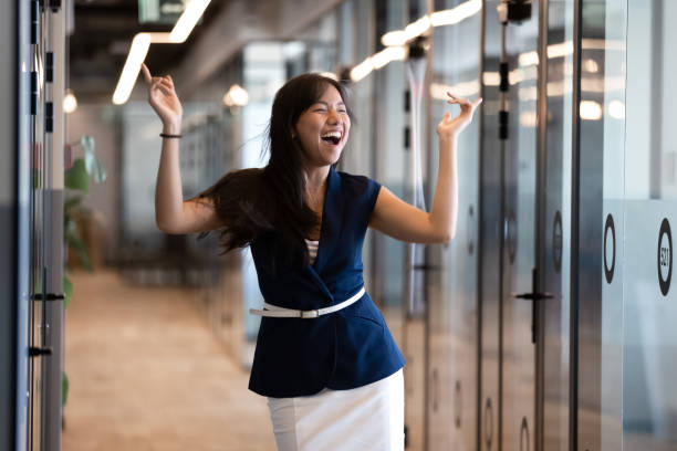 Excited funny young asian businesswoman celebrate success in victory dance Excited funny young asian business woman celebrate success in victory dance, happy euphoric proud chinese female professional winner feel overjoyed by corporate reward standing in office corridor happy friday stock pictures, royalty-free photos & images