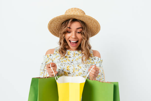Excited happy young woman wearing dress and straw hat smiling stock photo