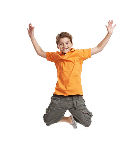 Excited, little boy jumping in mid air on white background "Portrait of happy, little boy jumping in mid air isolated on white background" boy jumping stock pictures, royalty-free photos & images