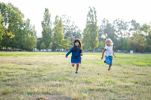 Excited little girls running on grass